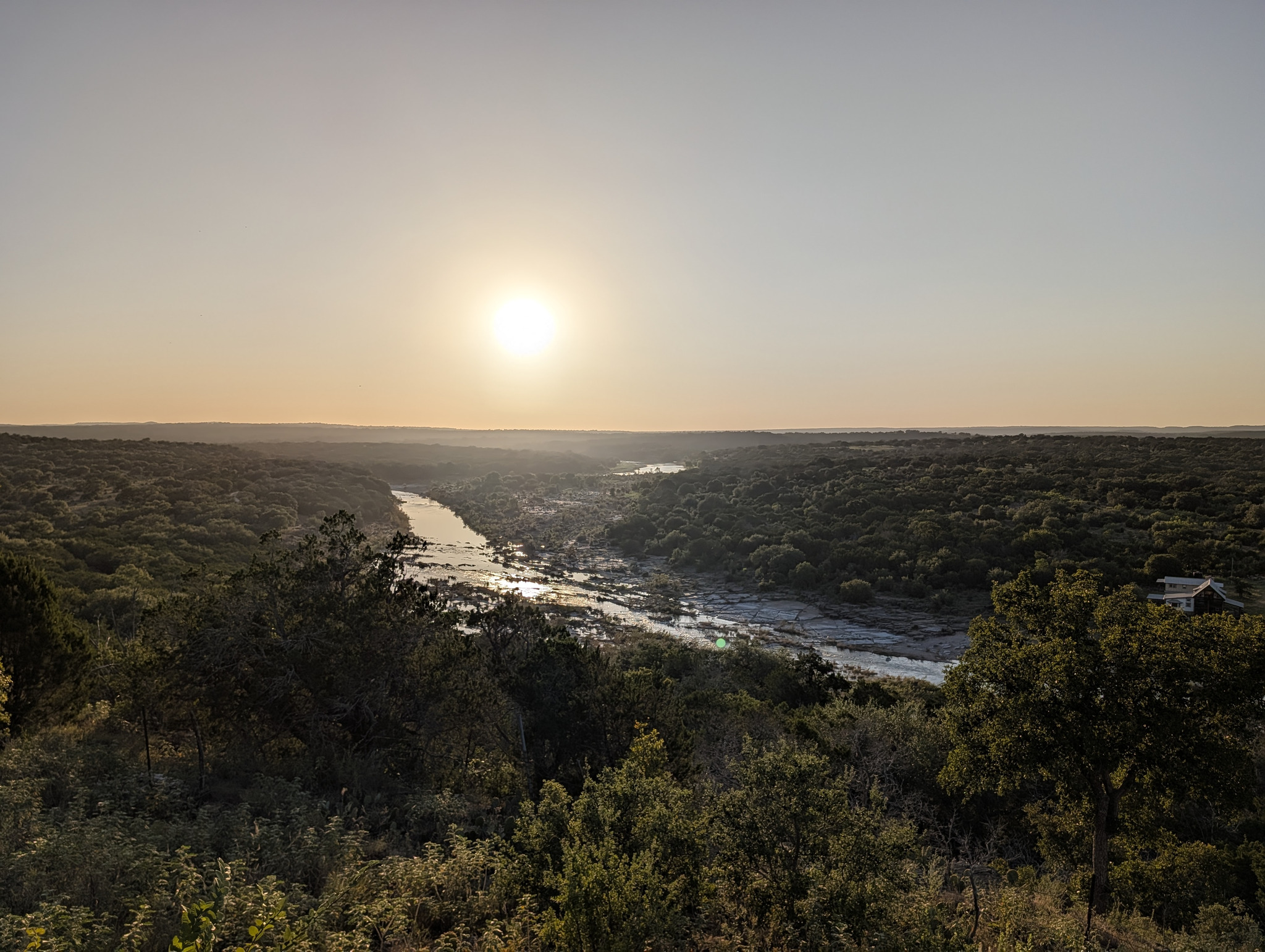 A river valley at sunset, seen from a hill