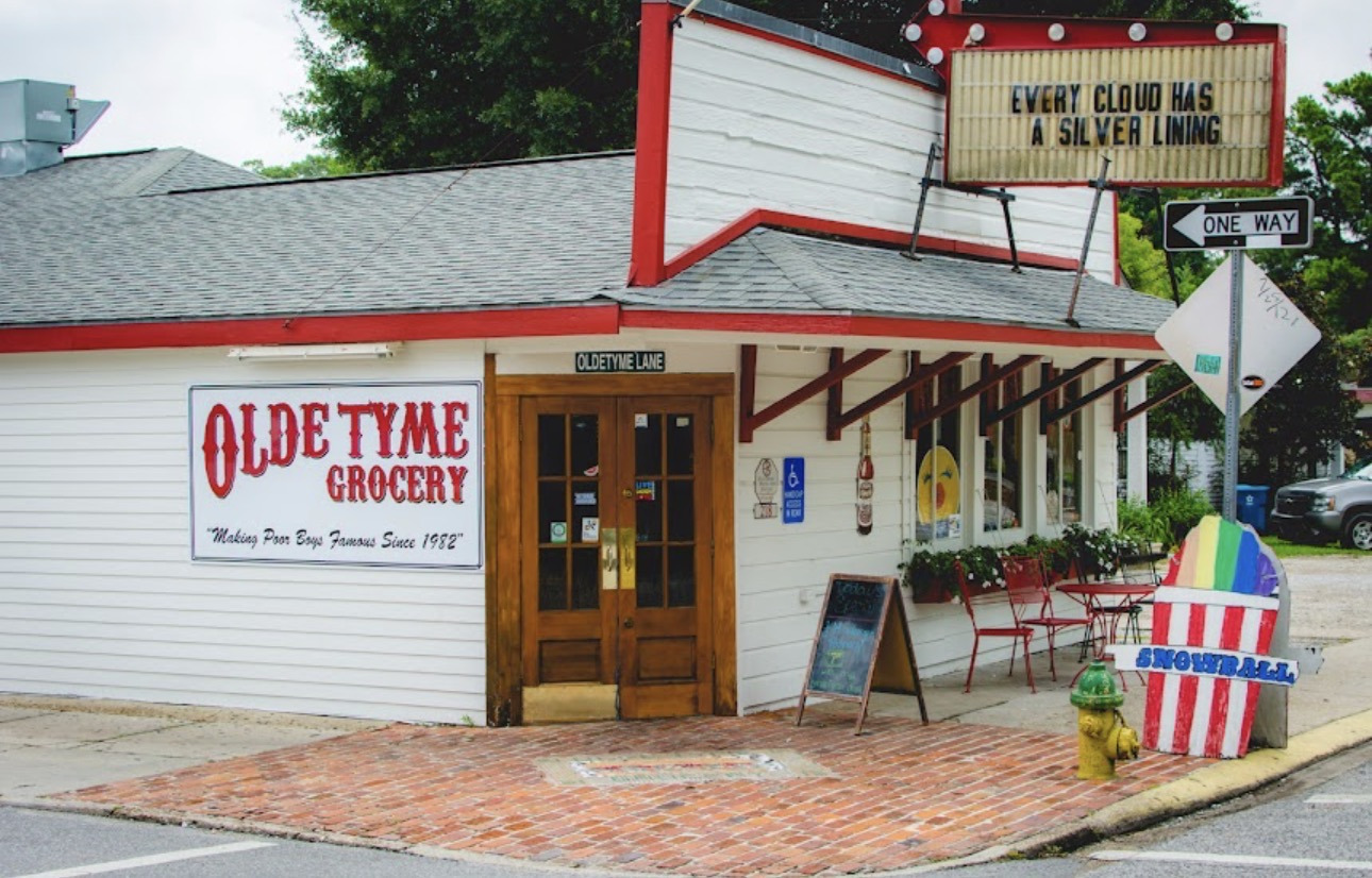 The storefront of Olde Tyme Grocery, with a snowball sign on the sidewalk